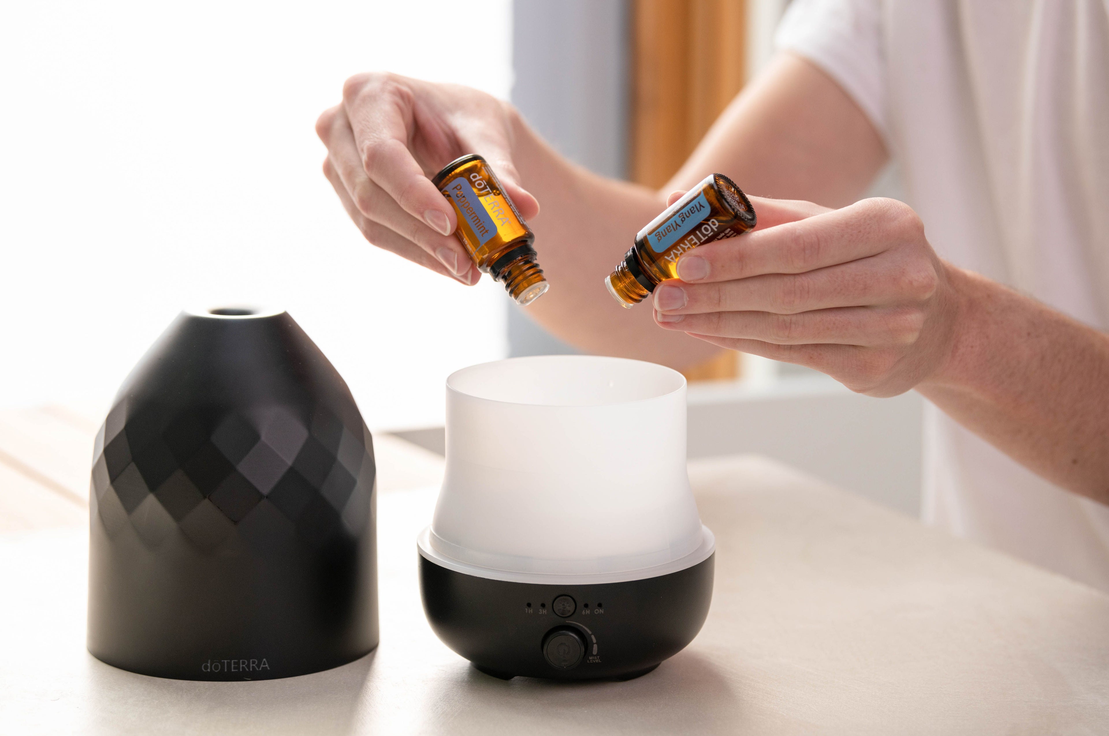 Adding essential oil drops to diffuser